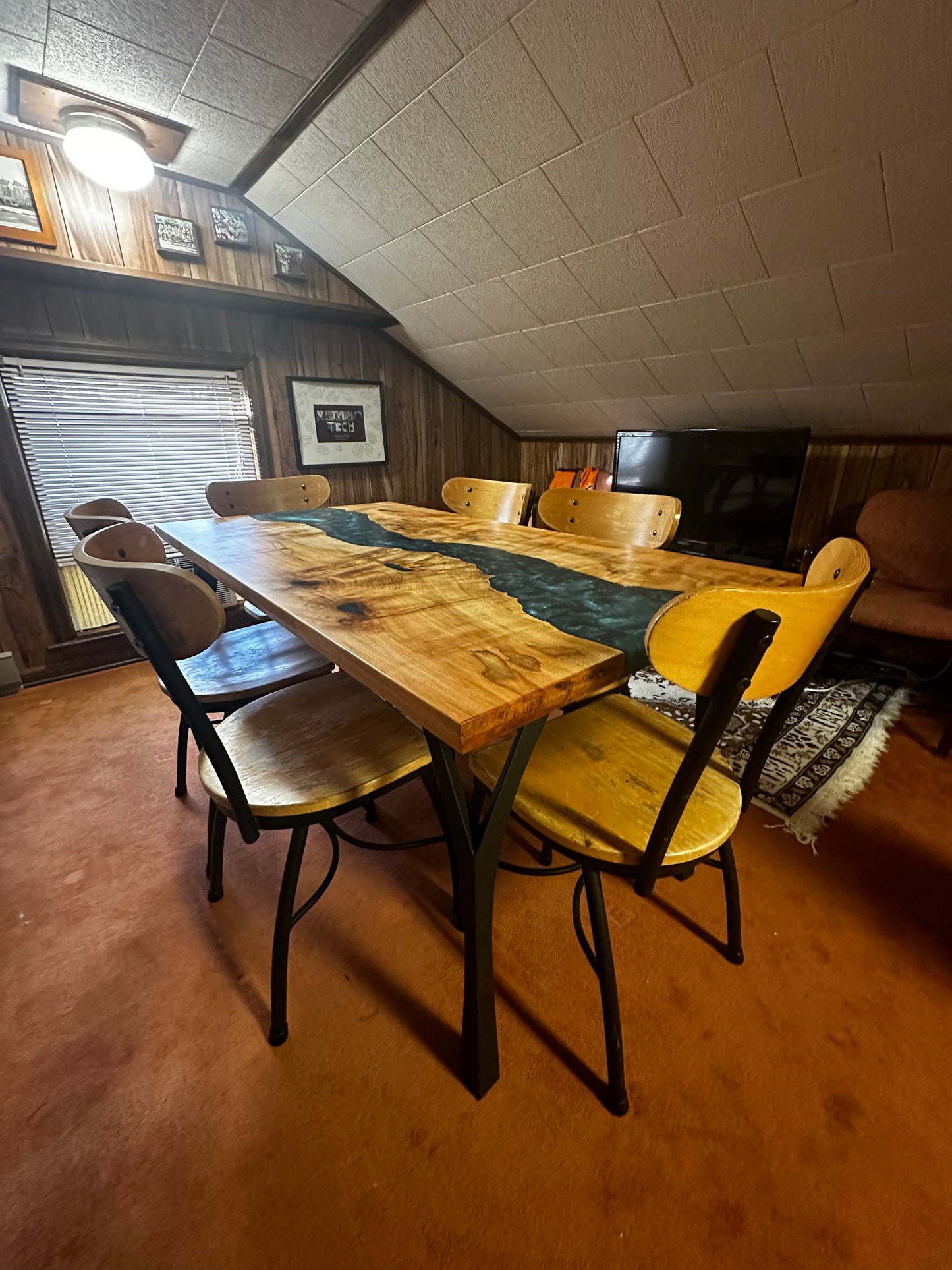 opposing view of dark blue epoxy river table in game room