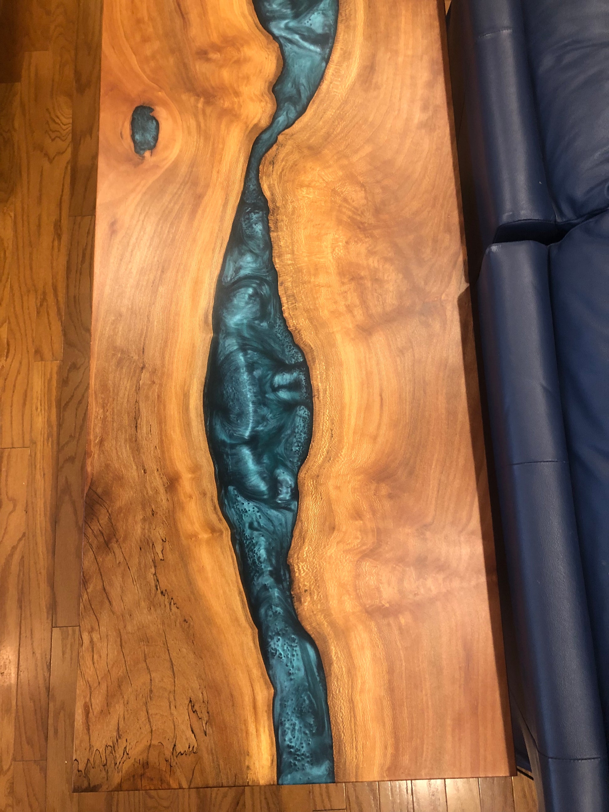 Overhead view of blue epoxy river table emphasizing blue river